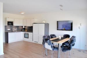 The White Pearl inkl Wäsche Set في هايليغنهافن: مطبخ مع طاولة وكراسي مع تلفزيون