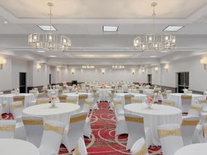 a banquet hall with white tables and chairs and chandeliers at Crowne Plaza Newark Airport by IHG in Elizabeth