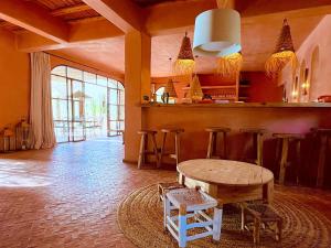 a room with a bar with a table and stools at Palais Bouchka in Essaouira