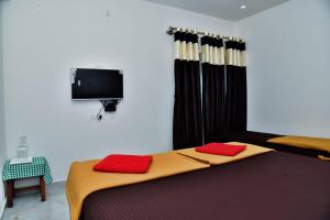 马迪凯里Coorg Balaji Palace Homestay Madikeri的一间卧室，床上有两个红色枕头