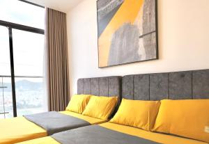a bedroom with a bed with yellow pillows at Classy Home - CSJ Tower Vũng Tàu, Luxury, Sky-Sea View and Walk-To-Beach in Xã Thang Tam +72 photos