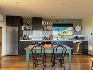 a kitchen with a blue table and chairs at Mount View Marrawah in Marrawah