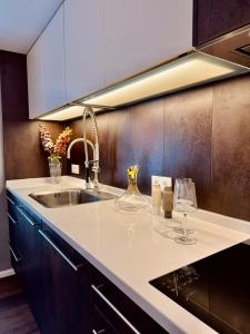 a kitchen with a sink and a counter with wine glasses at Lot54 Holiday Homes in Feuerscheid