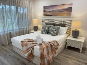 a bedroom with a large white bed with two lamps at Noosa Sound - 2brm Townhouse in Noosaville +17 photos