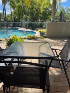 a table and chairs in front of a swimming pool at Noosa Sound - 2brm Townhouse in Noosaville