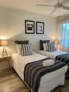 two beds in a room with two lamps at Noosa Sound - 2brm Townhouse in Noosaville