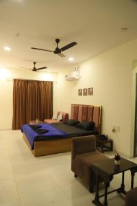 卡尔贾特Ivy Bliss Studio with Common Pool, B 10, Karjat的带一张大床和一张沙发的卧室