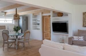 a living room with a couch and a table with chairs at Can Aisha in Es Pujols