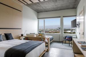 una camera con letto, scrivania e ampia finestra di The Source Hotel a Denver Altre 37 foto