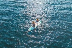 Due ragazze su una tavola da surf in acqua di First Camp Norsjø Telemark a Akkerhaugen