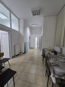 an empty room with tables and chairs and windows at Smestaj za radnike Stadion Lagator Loznica in Loznica +11 photos