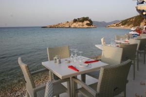 una mesa y sillas sentadas en la playa cerca del agua en Poseidon Studios, en Kokkari 17 fotos más