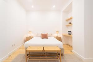 a white bedroom with a bed and a table at Santos Cozy Design Apartment in Lisbon