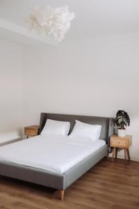 a bed with white sheets and pillows in a room at Snagov Forest Villa in Ciolpani