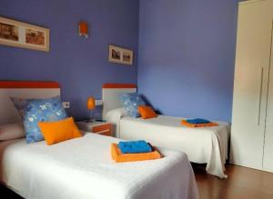 a room with two beds and a blue wall at Casa Rural El Montaraz de Gema in Gema +24 photos