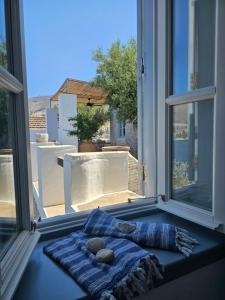 a window with a blue blanket and two rocks on it at The Anchor House in Symi
