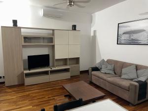 a living room with a couch and a flat screen tv at Le Palme in Lido di Ostia
