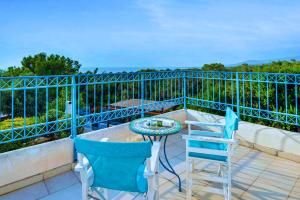 a balcony with two chairs and a table at Azzurro Holiday Villas in Peyia