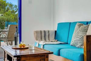 a living room with a blue couch and a table at Azzurro Holiday Villas in Peyia