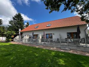 a white house with a fence and a yard at Wiedemann Heiko in Mellenthin