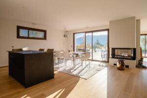 ヴェリエ・デュ・ラックにあるVilla Elegance - Vue Lacのテーブルと椅子のあるキッチンとリビングルーム