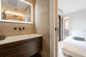 ヴェリエ・デュ・ラックにあるVilla Elegance - Vue Lacのベッドと洗面台と鏡のあるバスルーム +8枚の写真