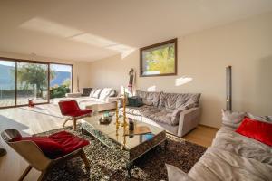 ヴェリエ・デュ・ラックにあるVilla Elegance - Vue Lacのソファとテーブルのあるリビングルーム