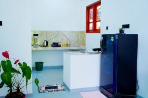 a kitchen with a refrigerator and a potted plant at White rose villa in Weligama