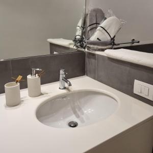 a white sink in a bathroom with towels on a counter at L' Approdo12 in Bari +24 photos