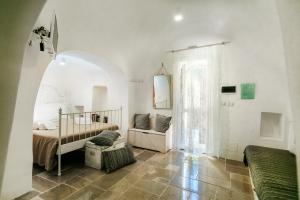 a white room with a bed and a window at Le Dimore di Trulli Mandorlo con piscina esclusiva in Putignano