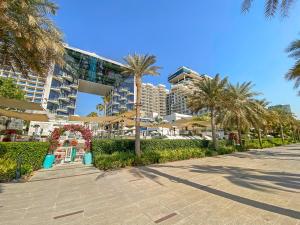 a street with palm trees and a large building at FIVE Palm Jumeirah Dubai Apartment with Private Pool in Dubai