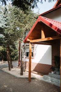 a pavilion at a building with trees in front of it at Snagov Forest Villa in Ciolpani +15 photos
