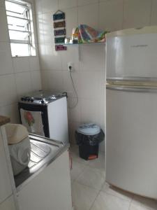 a small kitchen with a refrigerator and a trash can at excelente localização o mar na sua frente confira in São Vicente +38 photos