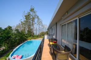 a balcony with a swimming pool on a house at Sinclairs Retreat Kalimpong in Kalimpong
