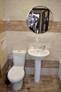 a bathroom with a toilet and a sink and a mirror at Central Apartment 4 in Stara Zagora