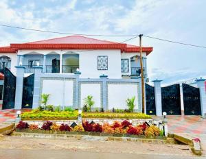 a white house with flowers in front of it at Lariappart in Yaoundé
