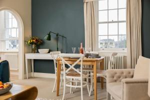 a kitchen and dining room with a table and chairs at Wolcote House in Cheltenham