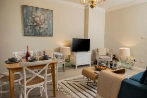 a living room with a table and a tv at Wolcote House in Cheltenham