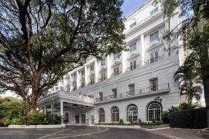 a white building with a tree in front of it at ITC Windsor, a Luxury Collection Hotel, Bengaluru in Bengaluru