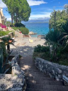 a walkway next to the water with trees and a building at Art Gallery suite in Vantačići +13 photos
