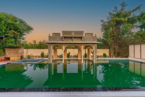 ウダイプールにあるIndulge Udaipur by Packの真ん中にガゼボ付きのスイミングプール