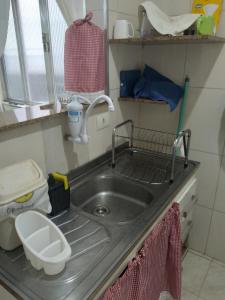 a kitchen counter with a sink and a toilet at excelente localização o mar na sua frente confira in São Vicente