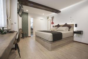 a bedroom with a bed and a television in it at Emilysuites - Malaga Centro Historico in Málaga