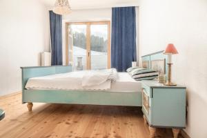 a bedroom with a blue bed and a window at Ferienwohnung Buchnerhof in Sankt Koloman