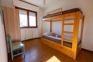 a bedroom with two bunk beds and a chair at Da Nonna Gina, casa luminosa con aria condizionata in Viareggio