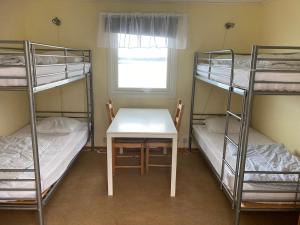 a room with three bunk beds and a table at Badholmens Vandrarhem in Fjällbacka