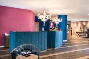 a room with pink and blue walls and a table at elaya hotel oberhausen, Trademark by Wyndham in Oberhausen