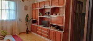 a living room with wooden cabinets and a television at Eira do vento in Cangas de Morrazo