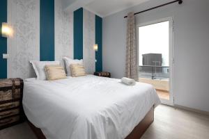 una camera da letto con un grande letto bianco con una finestra di Pérola Views Inn by Madeira Sun Travel a Porto Moniz