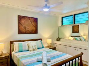 a bedroom with a bed and a ceiling fan at Poinciana 106 in Hamilton Island +5 photos
